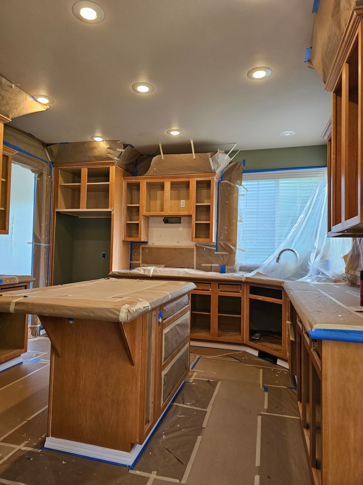 The kitchen before: orange wood cabinets masked for prep